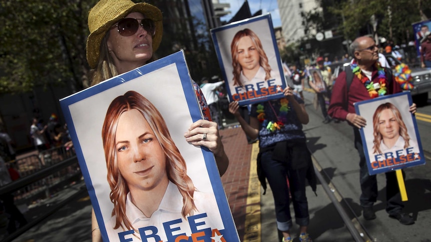 People hold signs calling for the release of imprisoned wikileaks whistleblower Chelsea Manning