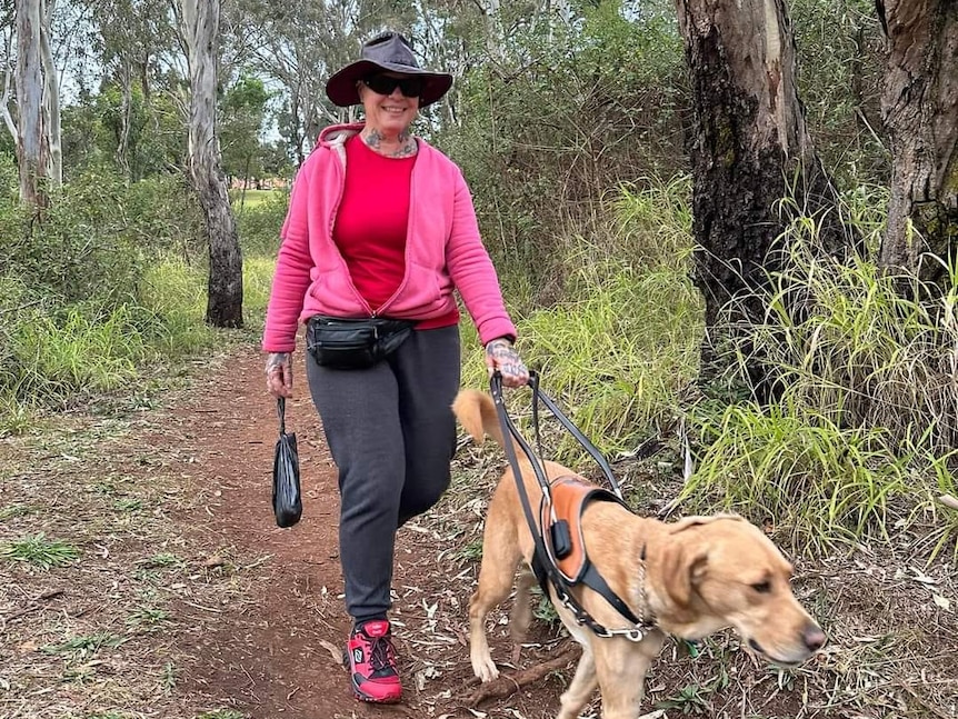 A woman on a track with a guide dog
