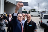 Prime Minister Malcolm Turnbull takes a selfie with workers in Perth.