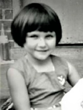 A young Debby Daniels sits on a step.