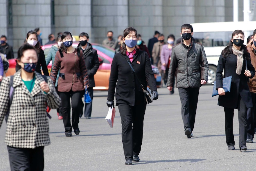 Pedestrians wear face masks to help prevent the spread of the new coronavirus in Pyongyang.