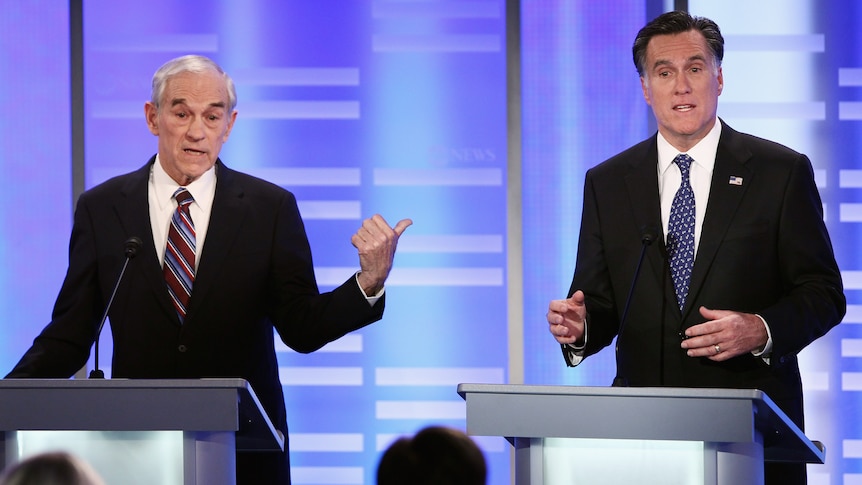 Republican presidential candidate Ron Paul gestures to former Massachusetts governor Mitt Romney