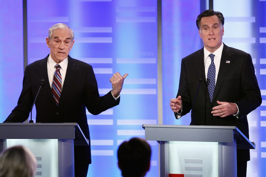 Republican presidential candidate Ron Paul gestures to former Massachusetts governor Mitt Romney