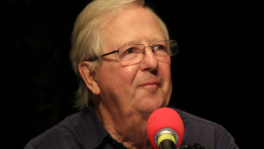 Tim Brooke-Taylor in front of a radio microphone recording an episode of I'm Sorry I Haven't a Clue.