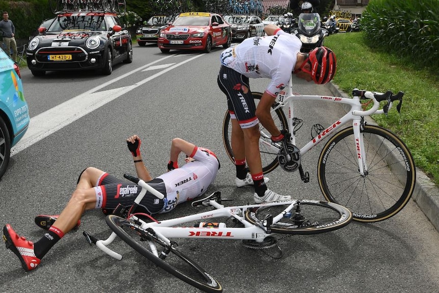 Spain's Alberto Contador, right, gets back on his bicycle after crashing with his teammate Austria's Michael Gogl.