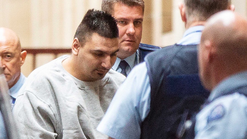 James Gargasoulas is escorted by officers from a prison van and into the Supreme Court of Victoria.
