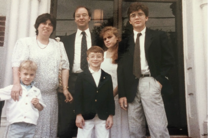 Old photo of a mother and father standing with their four children.