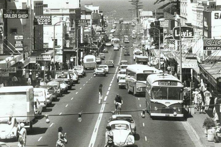 a black and white snap of a busy shopping street in the 70s