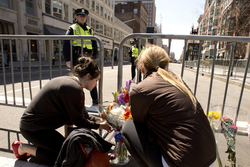 Women leave flowers at Boston bombings site