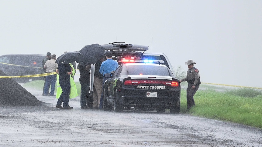 Law enforcement officers gather near the scene where the body of a woman was found near Laredo, Texas.