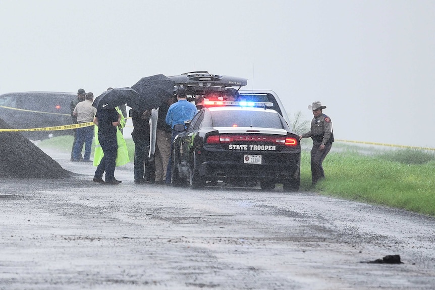 Law enforcement officers gather near the scene where the body of a woman was found near Laredo, Texas.