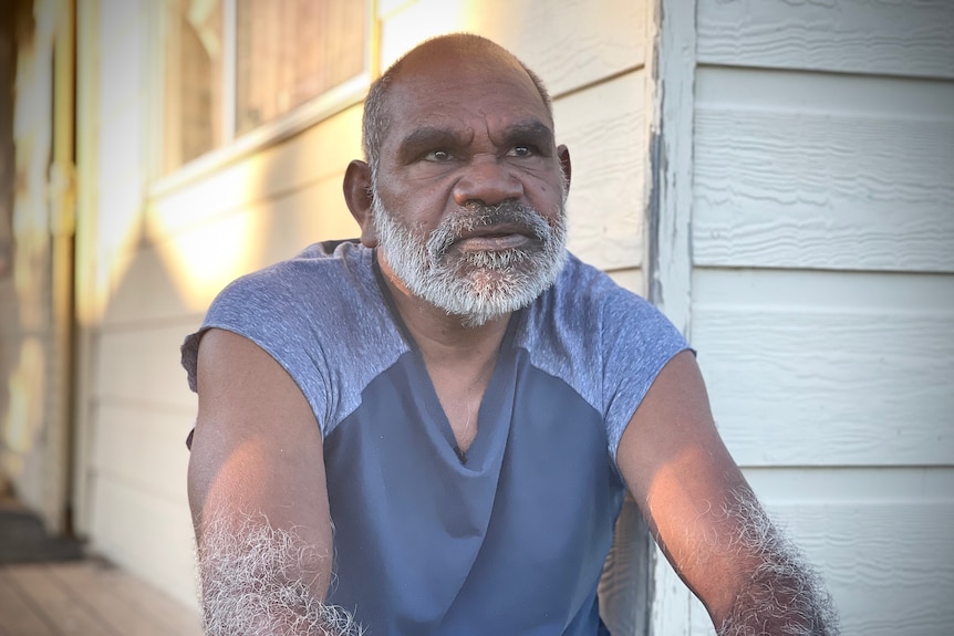 Glen Boney sits on a porch and looks off into the distance.