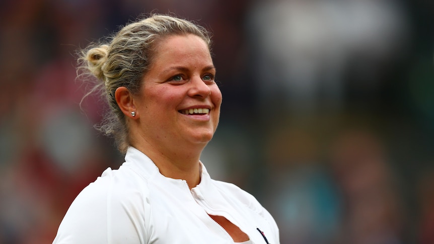 Kim Clijsters smiles and looks up wearing a white jacket