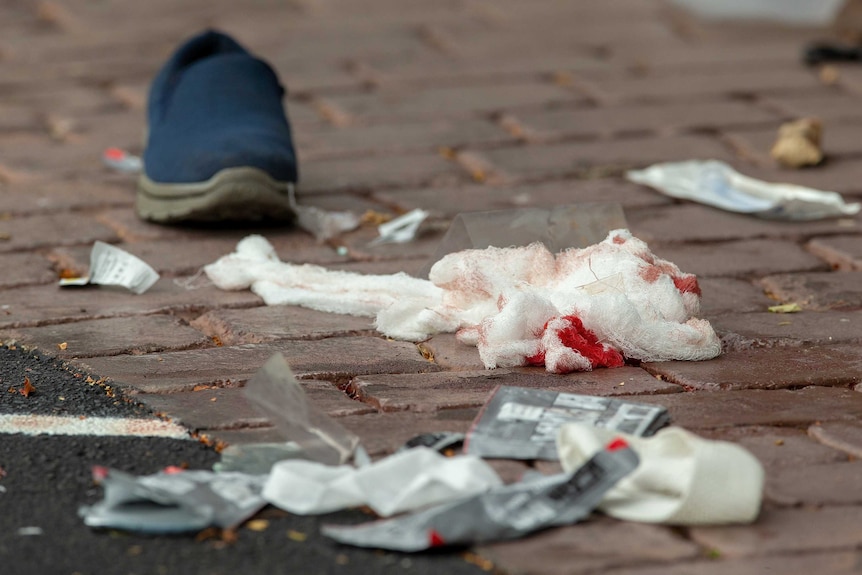 Bloodied bandages are seen on the road.