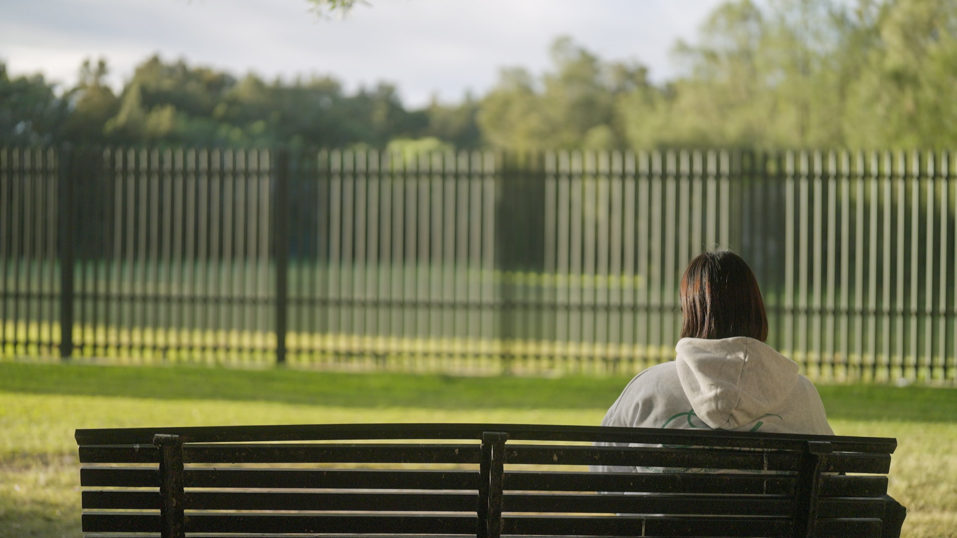 A woman sitting on a park bench.