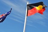 A close-up shot of Australian and Aboriginal flags against a blue sky.