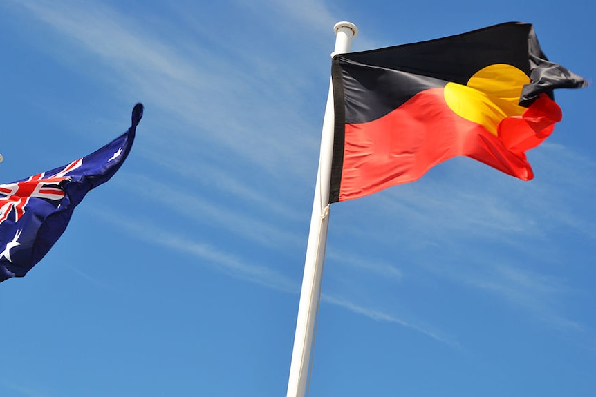 A close-up shot of Australian and Aboriginal flags against a blue sky.