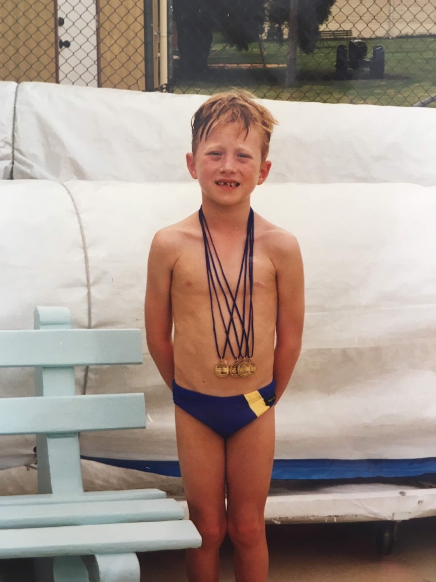 Daniel Smith with his junior swimming medals