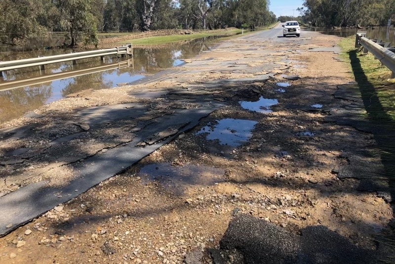 A road pavement that has been significantly damaged by rain and flooding.