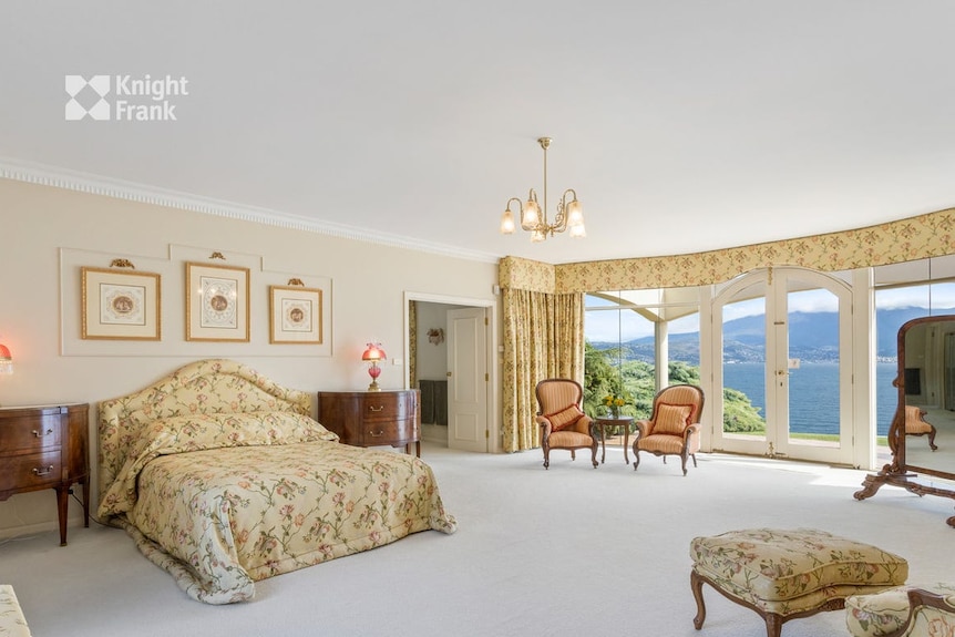 A view of a bedroom, with expansive views of the river.