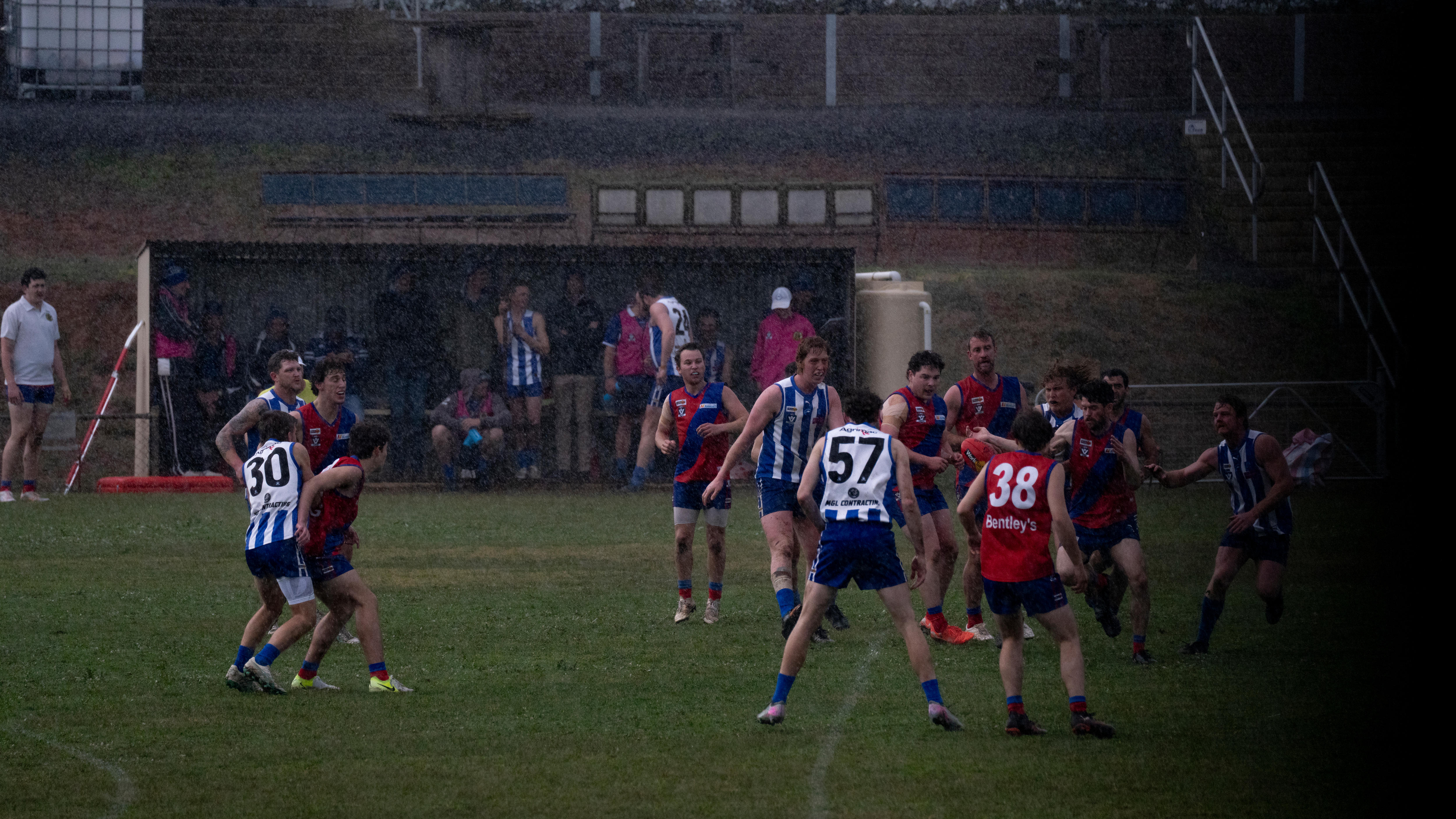 A pack of footballers tussle during a country football game.