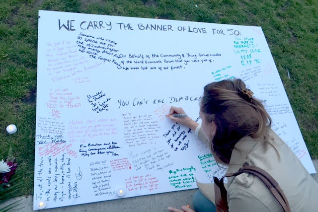 A woman signs a 'banner of love' for slain British Labour MP Jo Cox.