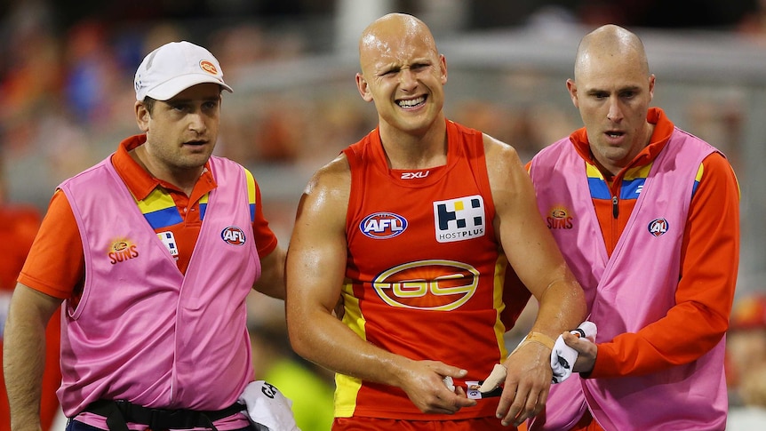 The Suns' Gary Ablett leaves the field after injuring his shoulder against Collingwood.