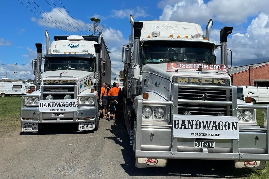 Two semi trailers with 'Bandwagon' signs on the front parked on a dirt road