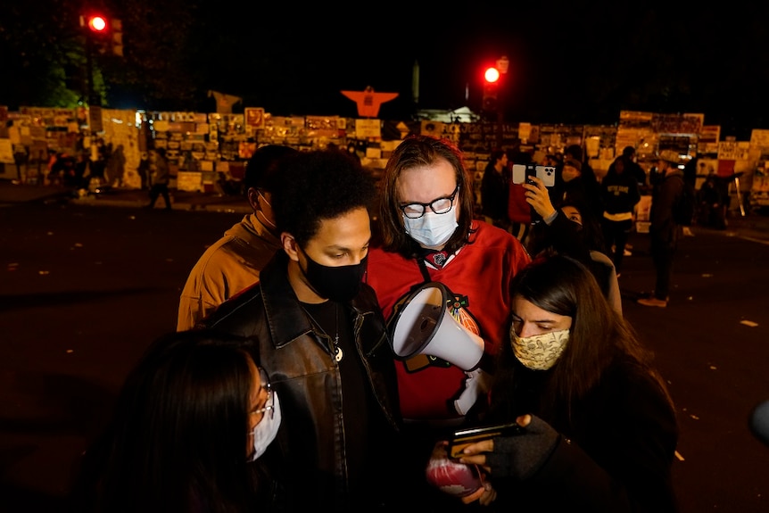 People wearing masks stand together