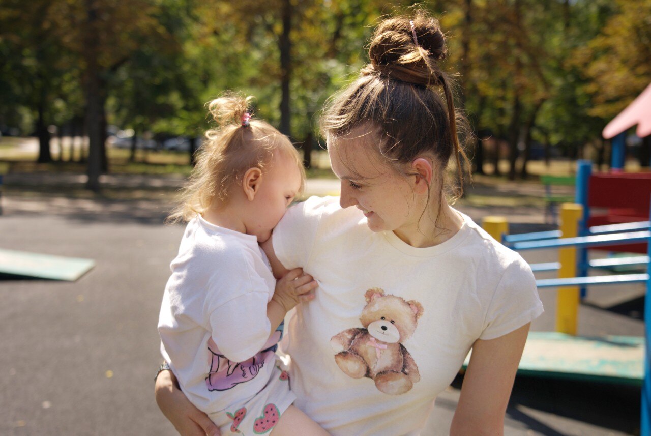 A woman holding and looking at a child.