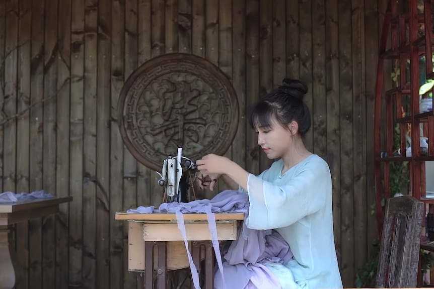 A young Chinese woman at a sewing machine 