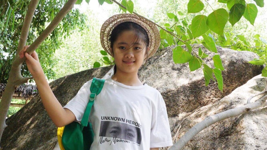 11-year-old Nguyen Bao Nguyen, daughter of Vietnamese political prisoner Nguyen Ngoc Nhu Quynh, stands in front of a tree