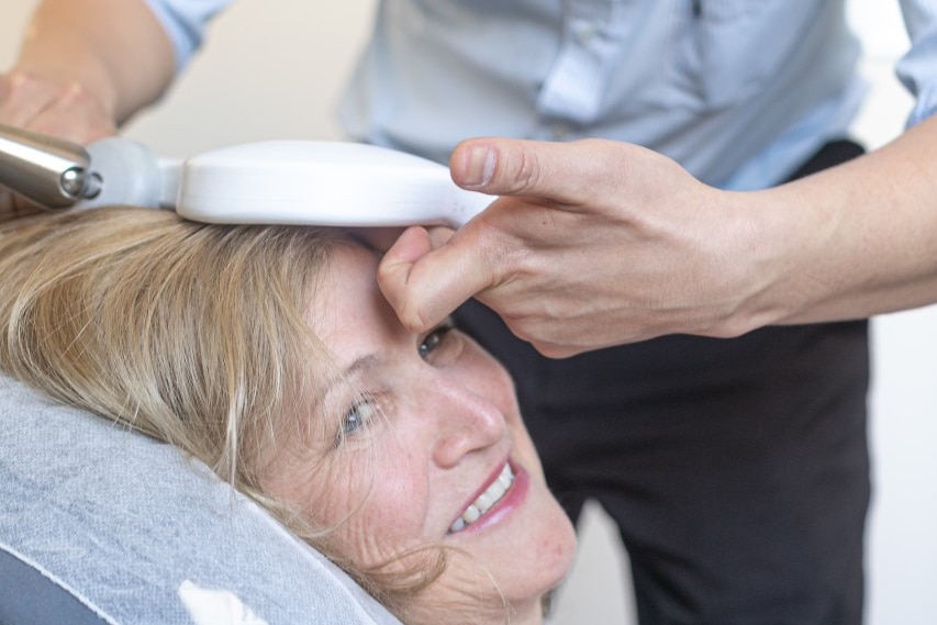 A woman receives TMS treatment.