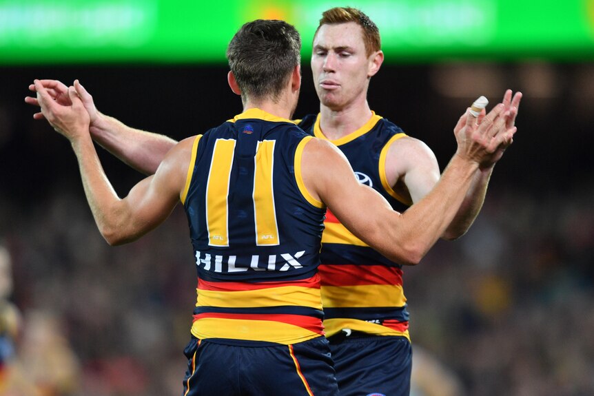 Paul Seedsman and Tom Lynch embrace after an Adelaide Crows goal against Carlton.