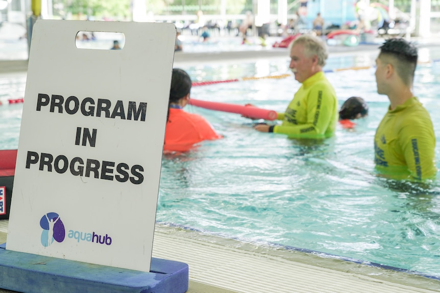 A sign beside a pool that reads 'Program in progress'