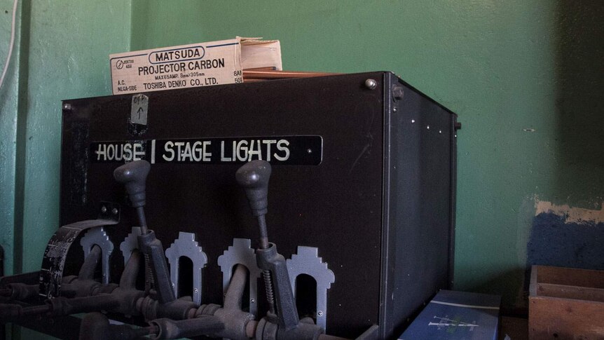 An old equipment box with the words House Stage and Light with a box of projector carbons on top