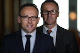 Richard Di Natale stands behind Adam Bandt as he addresses the media