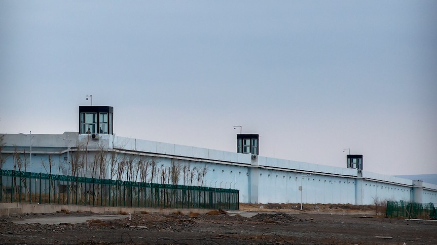 People stand in a guard tower on the perimeter wall of the Urumqi Number 3 Detention Centre