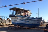 An asylum seeker boat which sailed into Geraldton in 2013 remains sitting in a shipyard 16 months later.