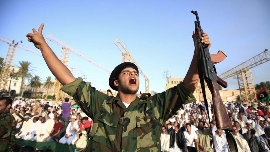An anti-Gaddafi fighter shouts during the Eid al-Fitr prayer in Tripoli.
