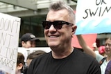 man in sunglasses with young people with protest signs