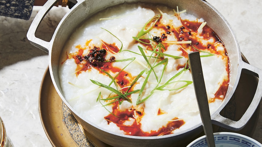 A hand cradling a bowl of fish congee