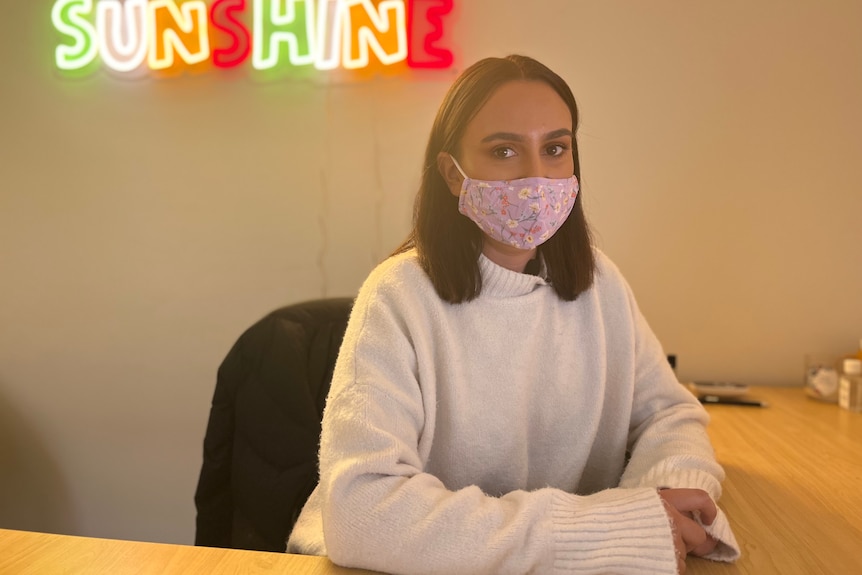 A woman sits at a desk. 