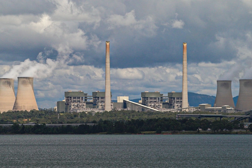 A large power station next to an inlet of water.