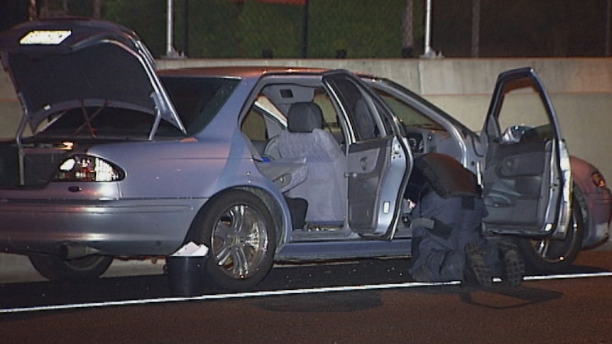 TV still of specialist policeman searching Glyn Newton's car on the Ipswich Motorway on Friday Feb 21, 2014