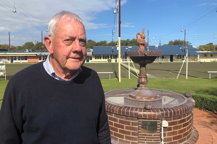 Bruce Williams standing in front of a bronze water fountain and bowls green