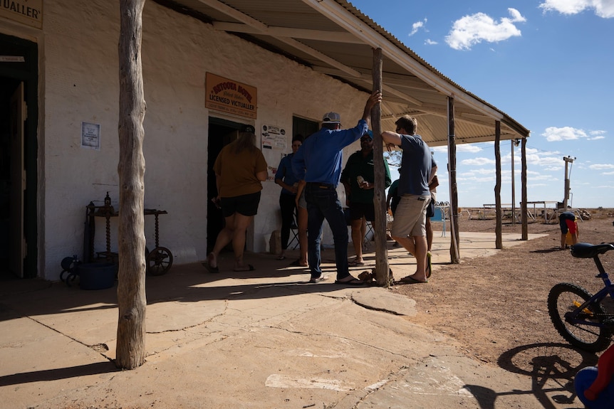 Men stand around outside the Betoota Pub