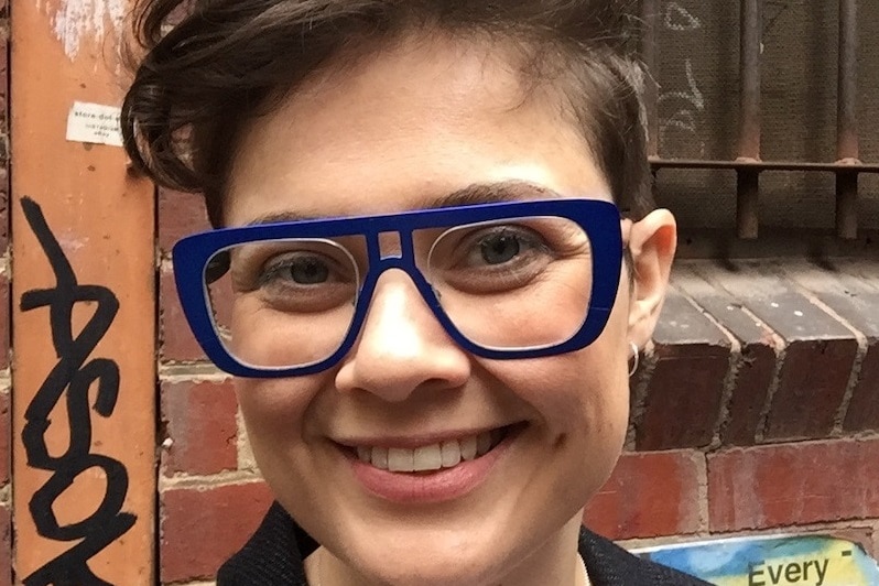 Dr Ruth Morgan wears heavy framed blue glasses and has short hair.