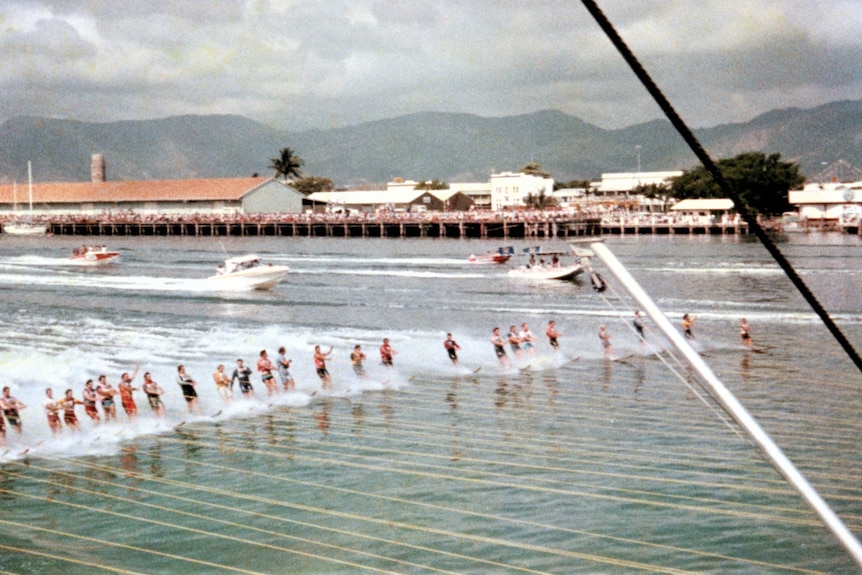 Photo of water skiers with wharves in the background