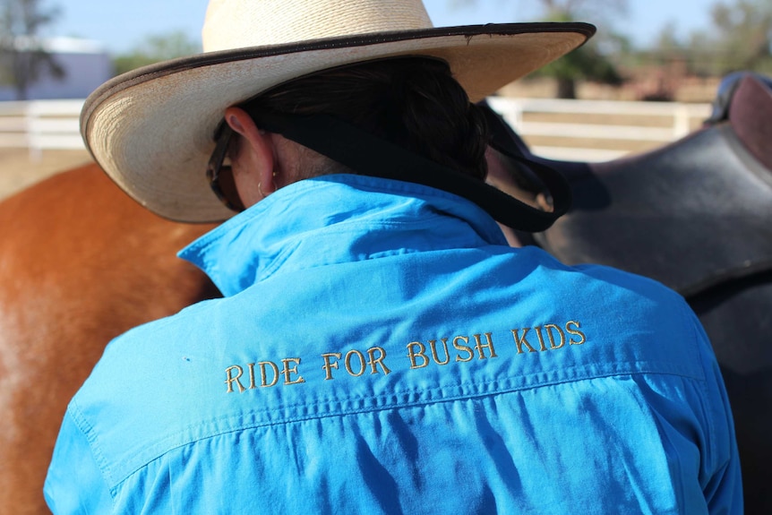 a shirt which reads "ride for bush kids" worn by a woman in a hat